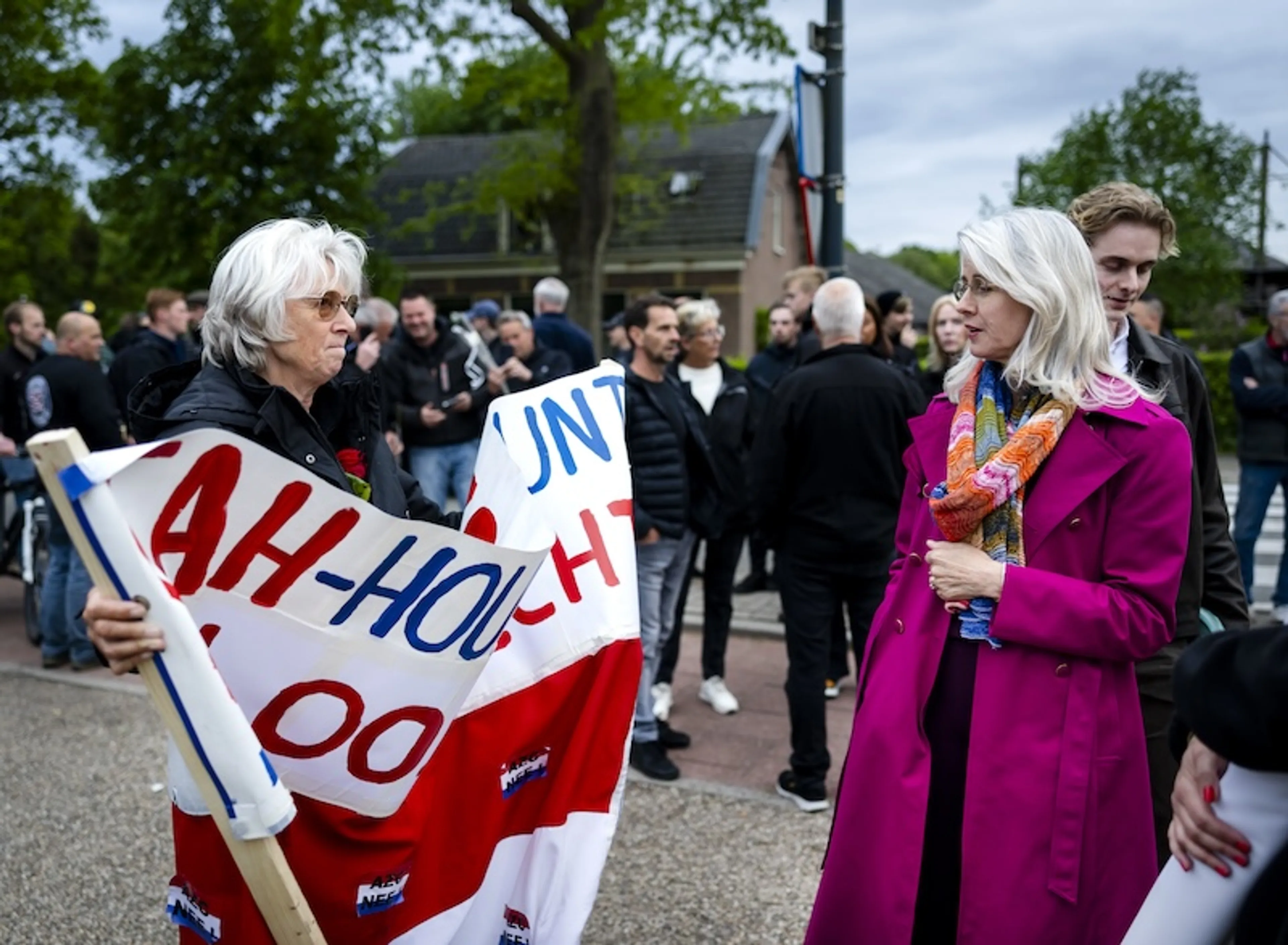 Mona Keijzer praat met demonstranten bij het oude gemeentehuis van Loosdrecht voorafgaand aan een protestmars tegen het asielzoekerscentrum. De actievoerders lopen richting het huidige gemeentehuis, waar 70 asielzoekers tijdelijk worden opgevangen.