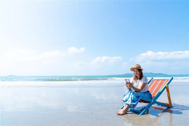 vrouw op het strand - vakantiegangers zijn geliefd doelwit voor digitale oplichting.