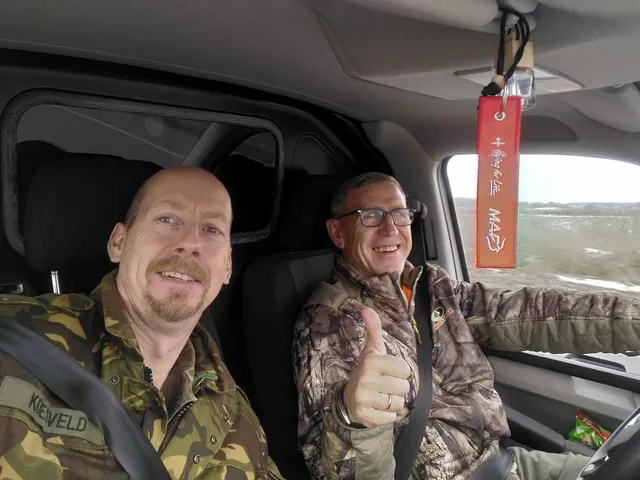 Jan Koesveld (links) onderweg in Oekraïne tijdens een transport van gesneuvelden samen met de Oekraïense kapelaan Valentin.