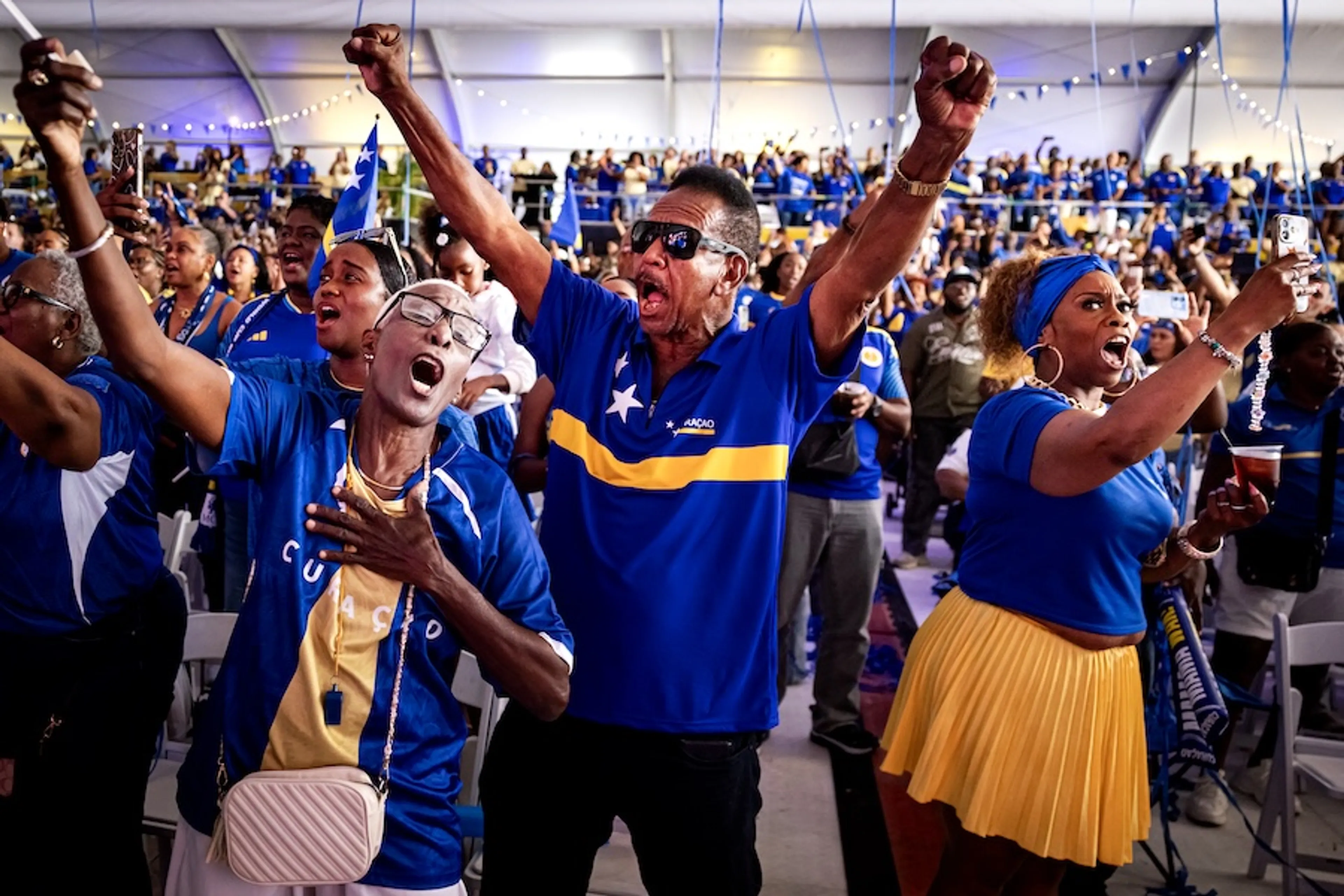Voetbalfans kijken de wedstrijd Curaçao-Duitsland op een groot scherm in Willemstad.