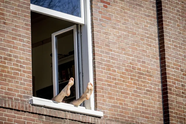 Persoon zoekt in huis verkoeling tijdens hittegolf.