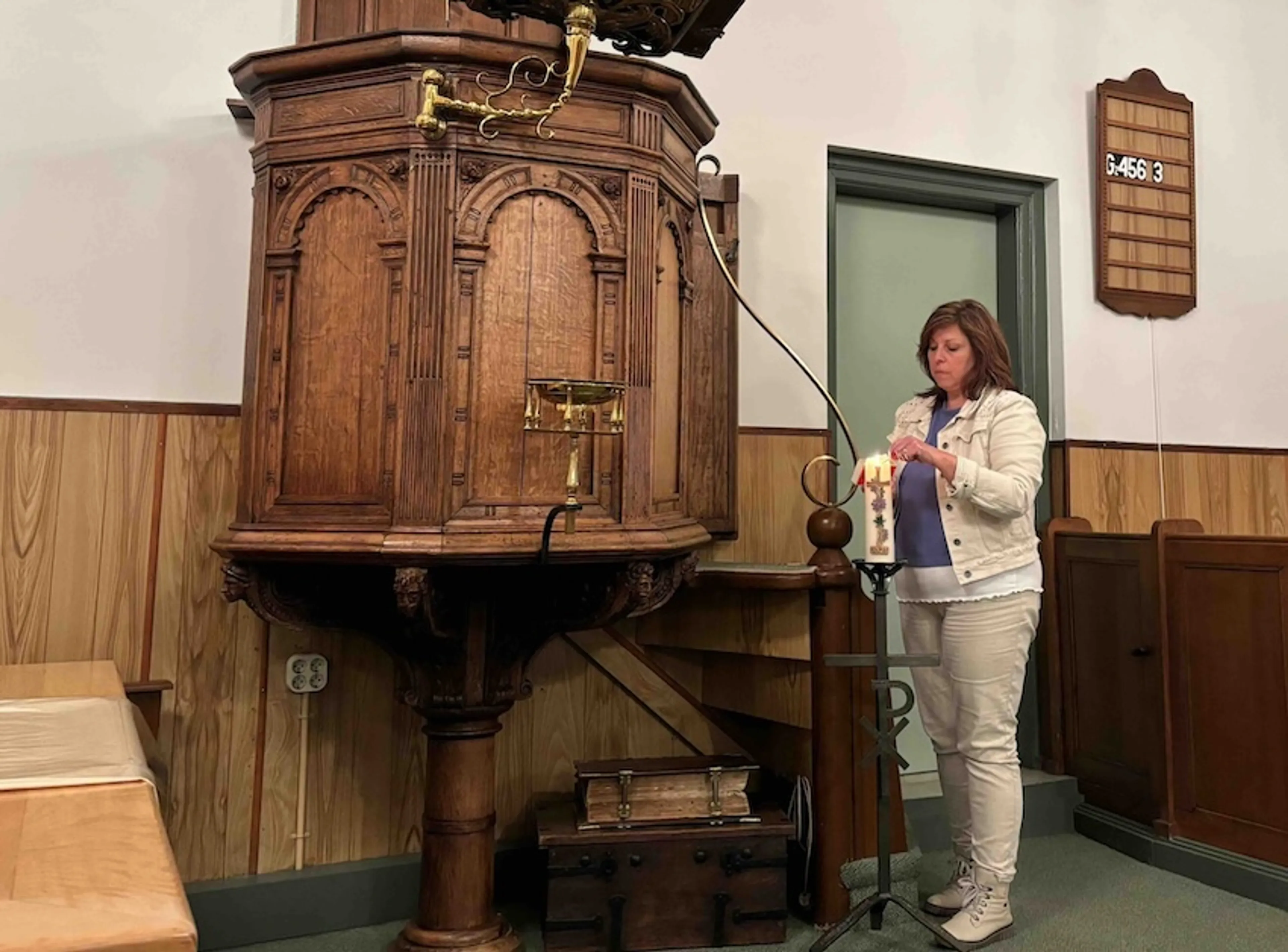 Margreet steekt een kaars aan in het monumentale kerkje van Moerdijk waarbij zij zo betrokken is. Ook dit kerkje dreigt te verdwijnen en daarmee een hechte gemeenschap.