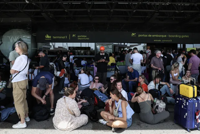 Forenzen wachten bij de ingang van de vertrekhal van de luchthaven Humberto Delgado in Lissabon, omdat het gebied is afgesloten vanwege de stroomstoring die Spanje en Portugal treft, in Lissabon, Portugal, 28 april 2025. De stroomstoring raakte grote delen van Spanje en breidde zich uit naar buurlanden Portugal en Frankrijk, waardoor transportsystemen, internetverbindingen en het dagelijks leven werden verstoord, aldus de autoriteiten. De exacte oorzaak van de stroomstoring is nog onbekend.