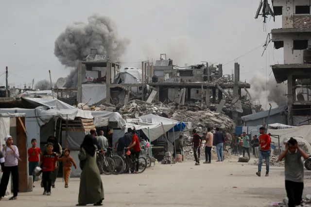 Palestijnen rennen weg om dekking te zoeken terwijl een Israëlische aanval het huis (L) van de familie Hmeid in Jabalia, in het noorden van de Gazastrook, treft op 15 mei 2025. Er wordt hevig gevochten in Gaza, waar volgens de civiele bescherming 80 mensen zijn omgekomen door Israëlische bombardementen op 14 mei, onder wie 59 in het noorden.