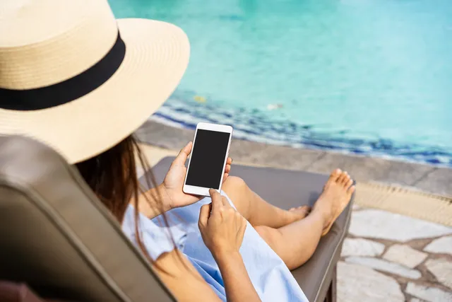 vrouw zit in de zomer op smartphone.