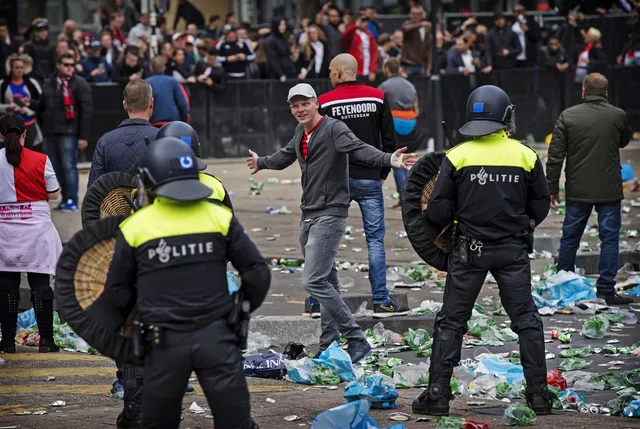 De ME van de politie vecht tegen voetbalhooligans die aan het relschoppen zijn.